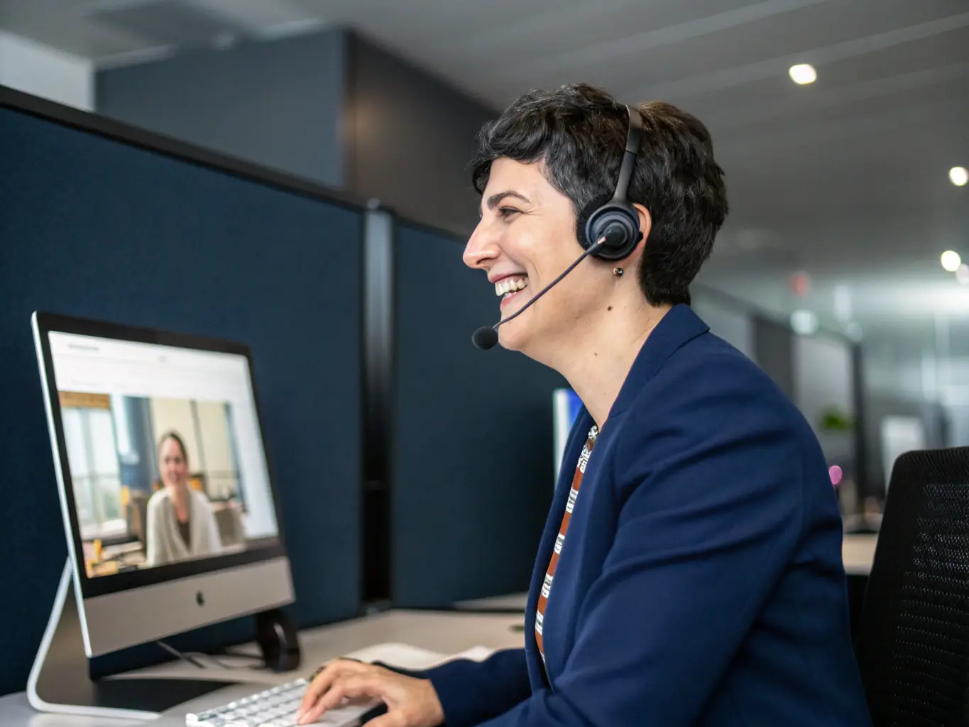 A customer service representative smiling and assisting a client via video call, showcasing HostingHighTech's commitment to providing excellent customer support and building strong client relationships.
